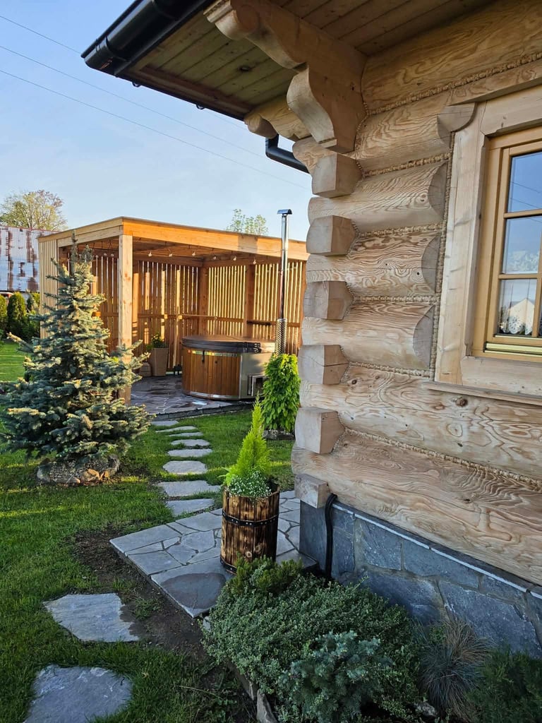 Domek z drewnianą balią sauna, kamienną ścieżką i zielonym trawnikiem